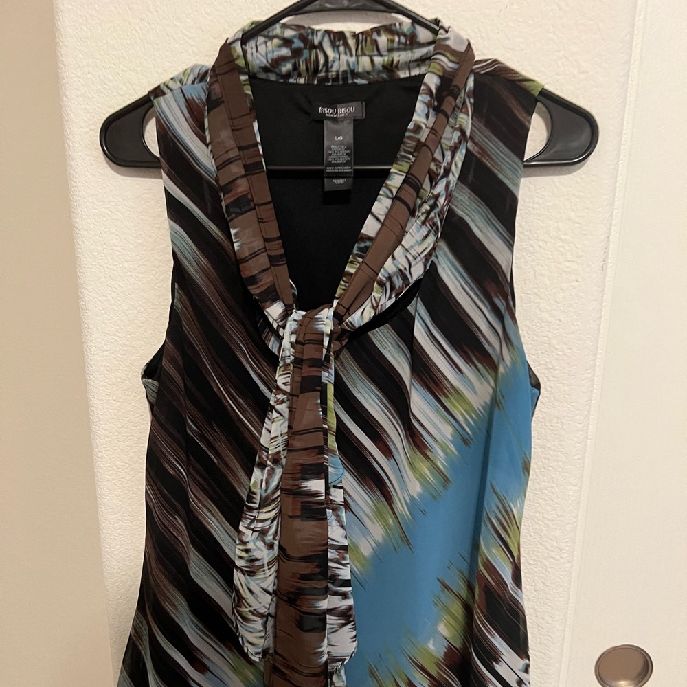 Bisou Bisou sleeveless blouse. Fun colorful print with tie accent. Size L